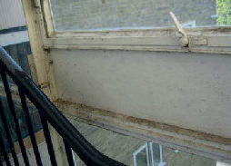 The window is in very poor condition; the frame and glass is covered in excessive cobwebs, dust and dirt.