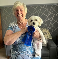 A lady holding her pet dog