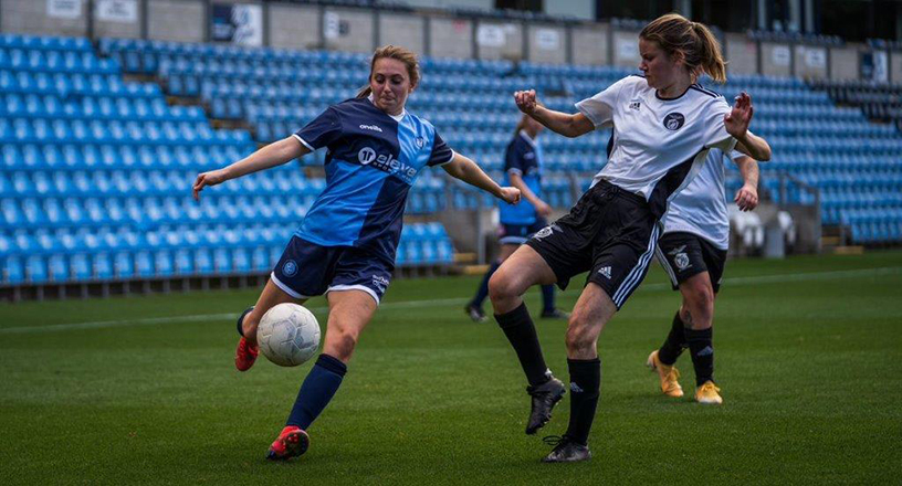 A female football player kicking a ball