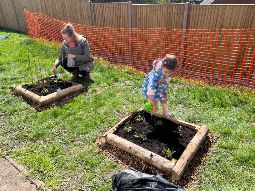 A mother and daughter watering plants