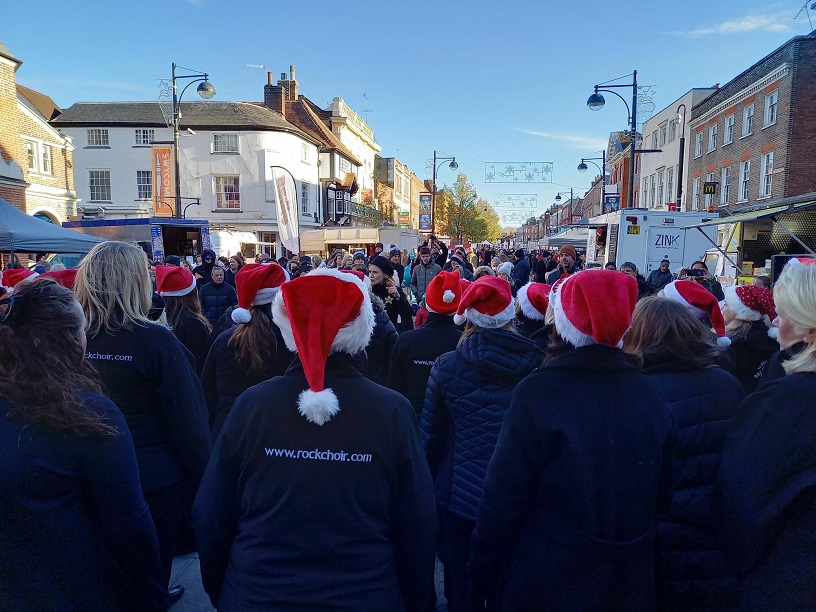 The back of the members of the Rock Choir singing at the Christmas market