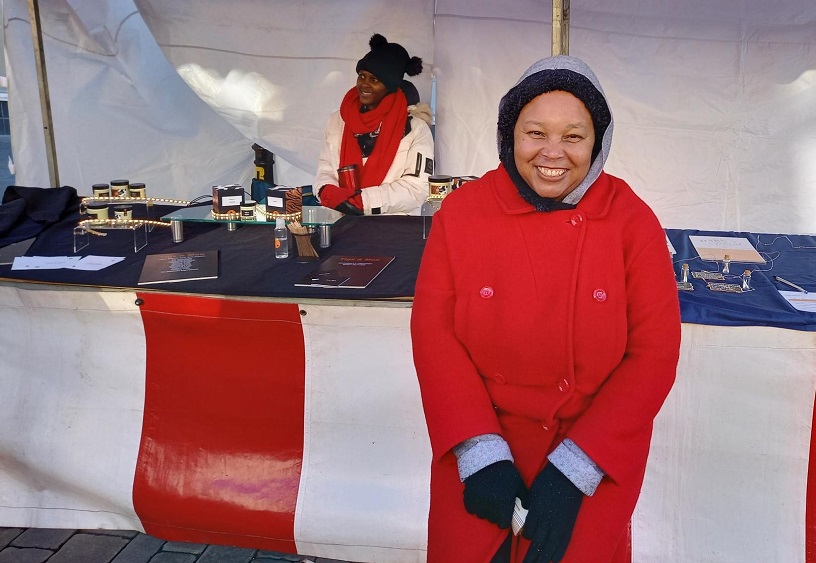 A lady standing in front of a stall at the Christmas market