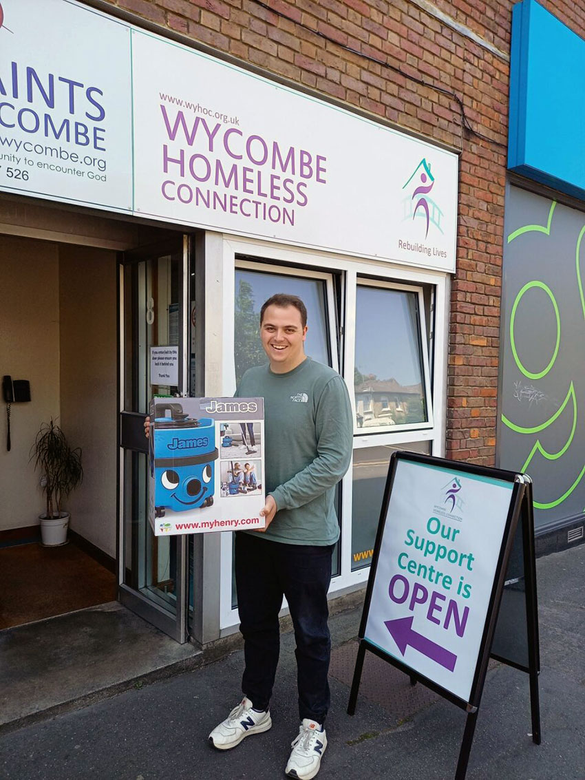 Fin, who works in the Homelessness Prevention Team at Wycombe Homeless Connection, standing outside their offices with the new vacuum cleaner