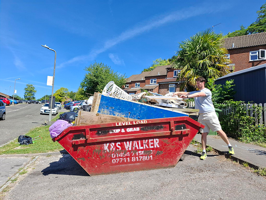 Red Kite Member Of Staff Placing Rubbish Into A Red Skip