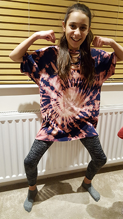 Springboard Blog Clothing Recycling - A young girl modelling her tie-dyed t-shirt