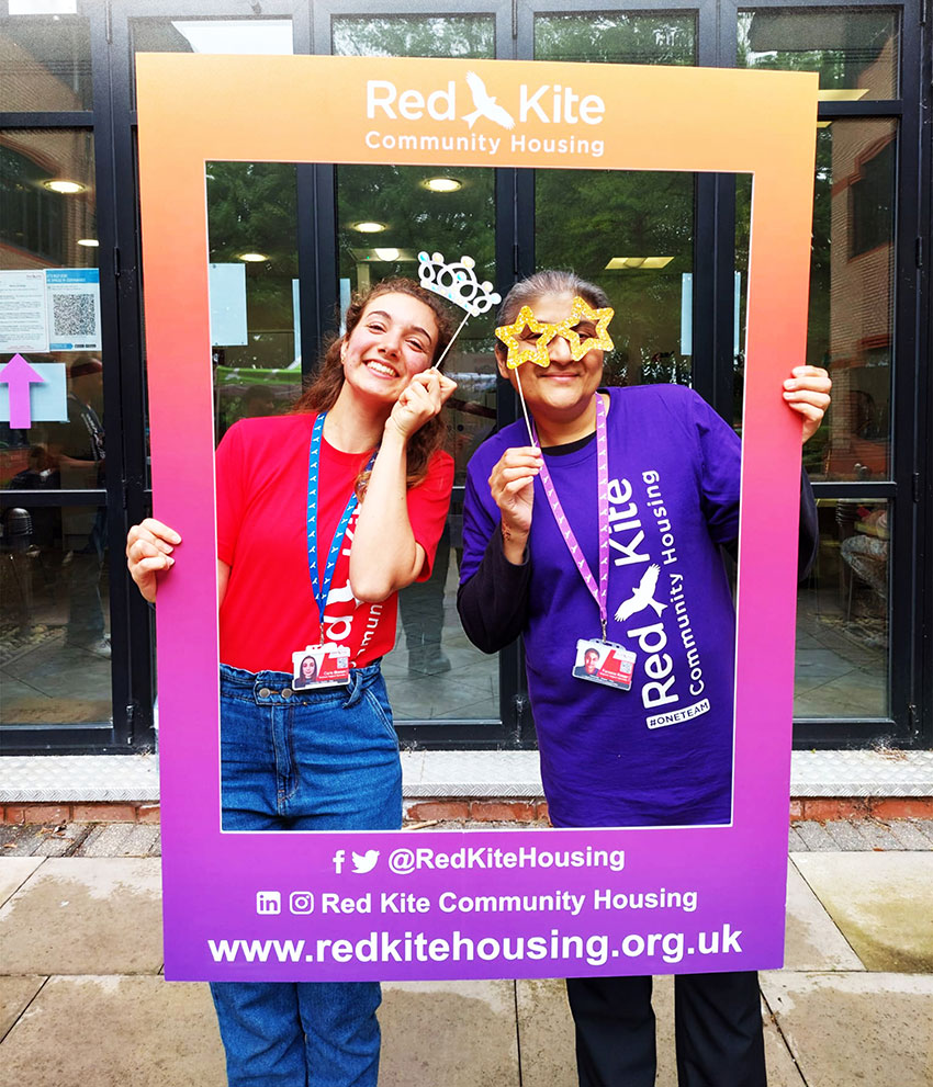 Two Red Kite members of staff holding up an Instagram-style selfie frame