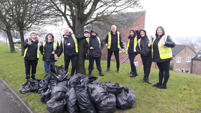 Downley Estate Inspection - Staff in high vis posing for a group shot with full bin bags of rubbish