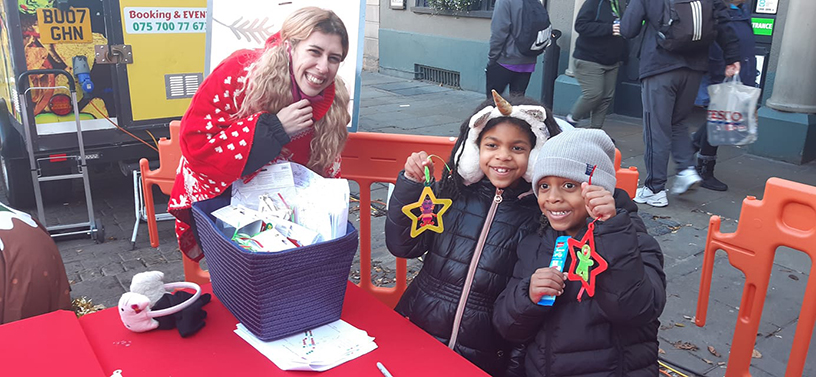 Children sitting at a table showing their crafts