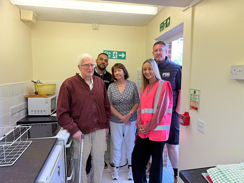 Tenants From Gweneth Court Smiling In Their New Kitchen With Red Kite And FSG Colleagues
