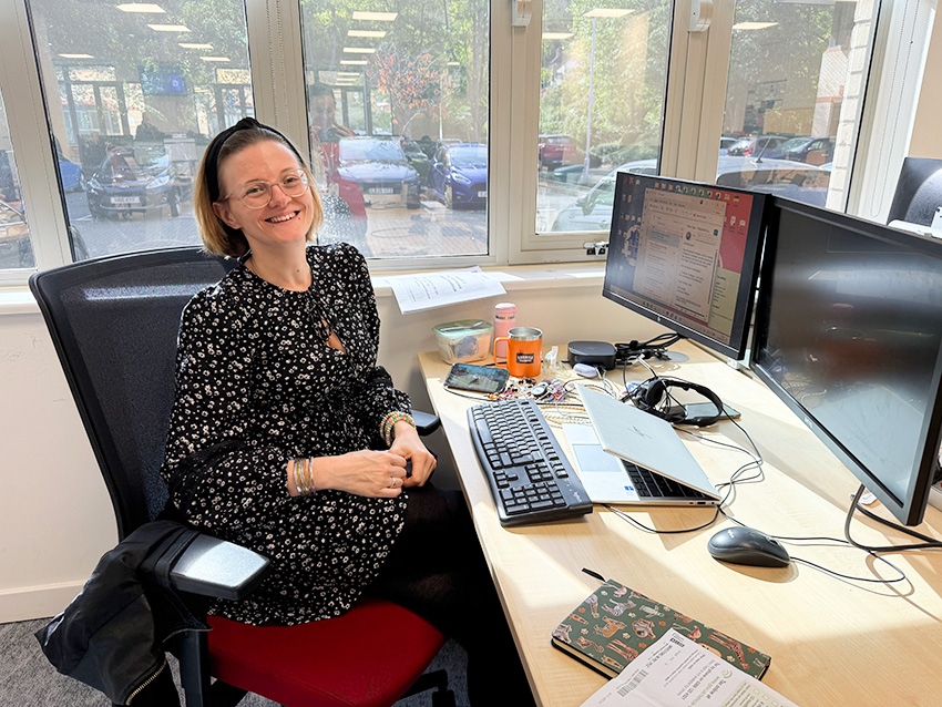 Member of staff smiling at desk