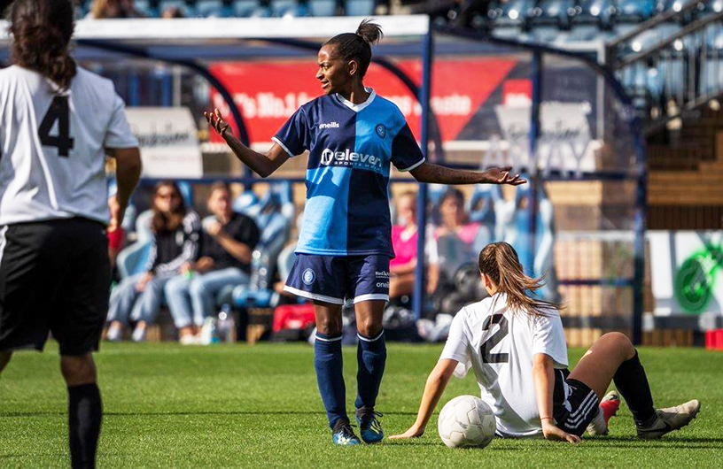 A female football player shrugging her shoulders during a game