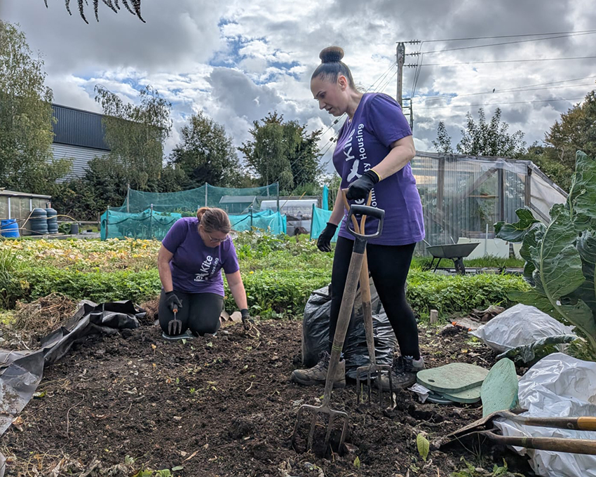 Two members of Red Kite's Senior Leadership Team digging over a vegetable bed at the Grow Together community allotments in Loudwater, High Wycombe