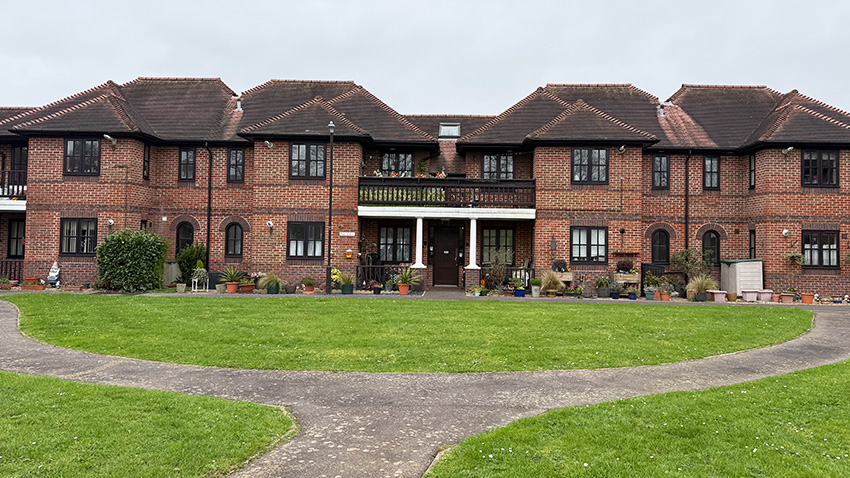 A Block Of Flats With Plant Pots Along The Front