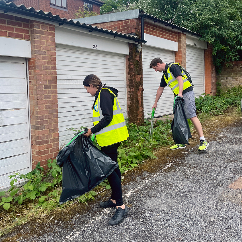 Members of Red Kite's Estates team picking litter by some garages