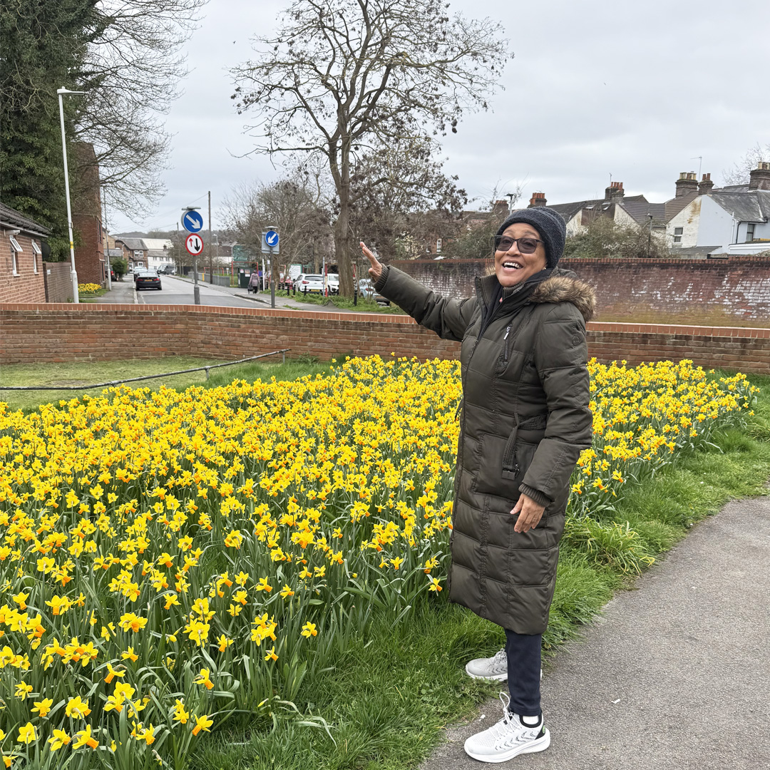 A Woman Stood Next To A Row Of Daffodils