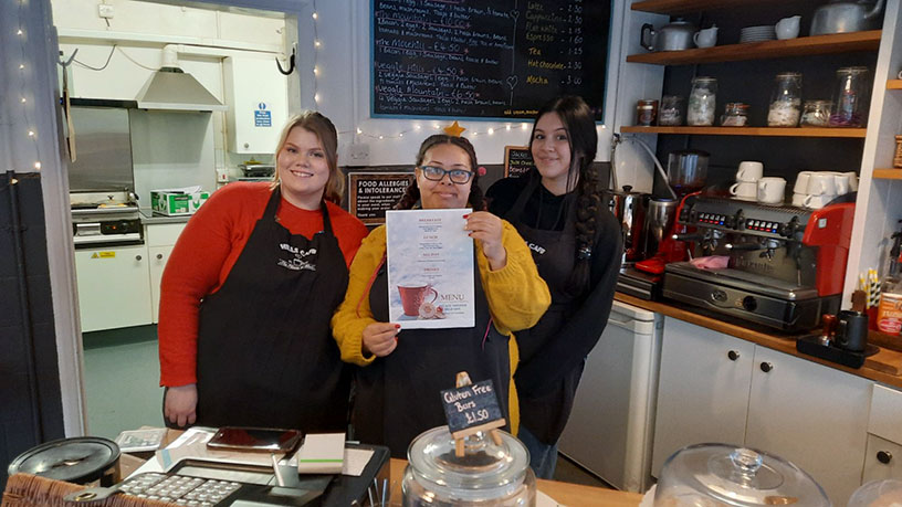 Hills Café staff members with a Red Kite menu