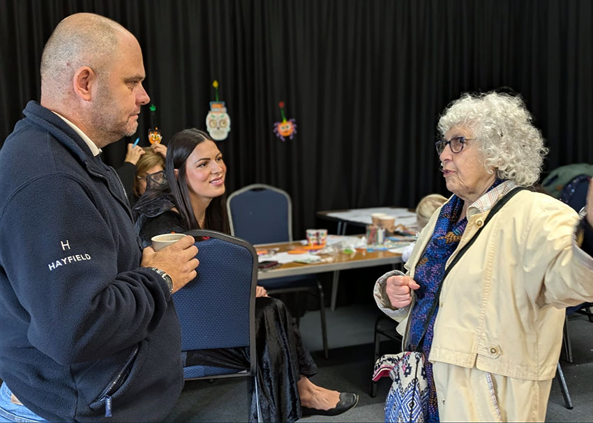 Hayfield staff in conversation with a local resident