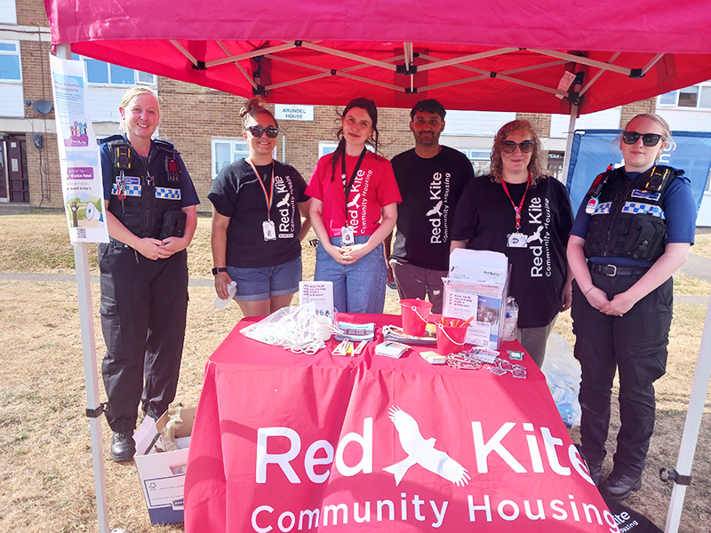 Red Kite Colleagues With Thames Valley Poilice Officers Standing Behind Red Kite Table At The Roadshow