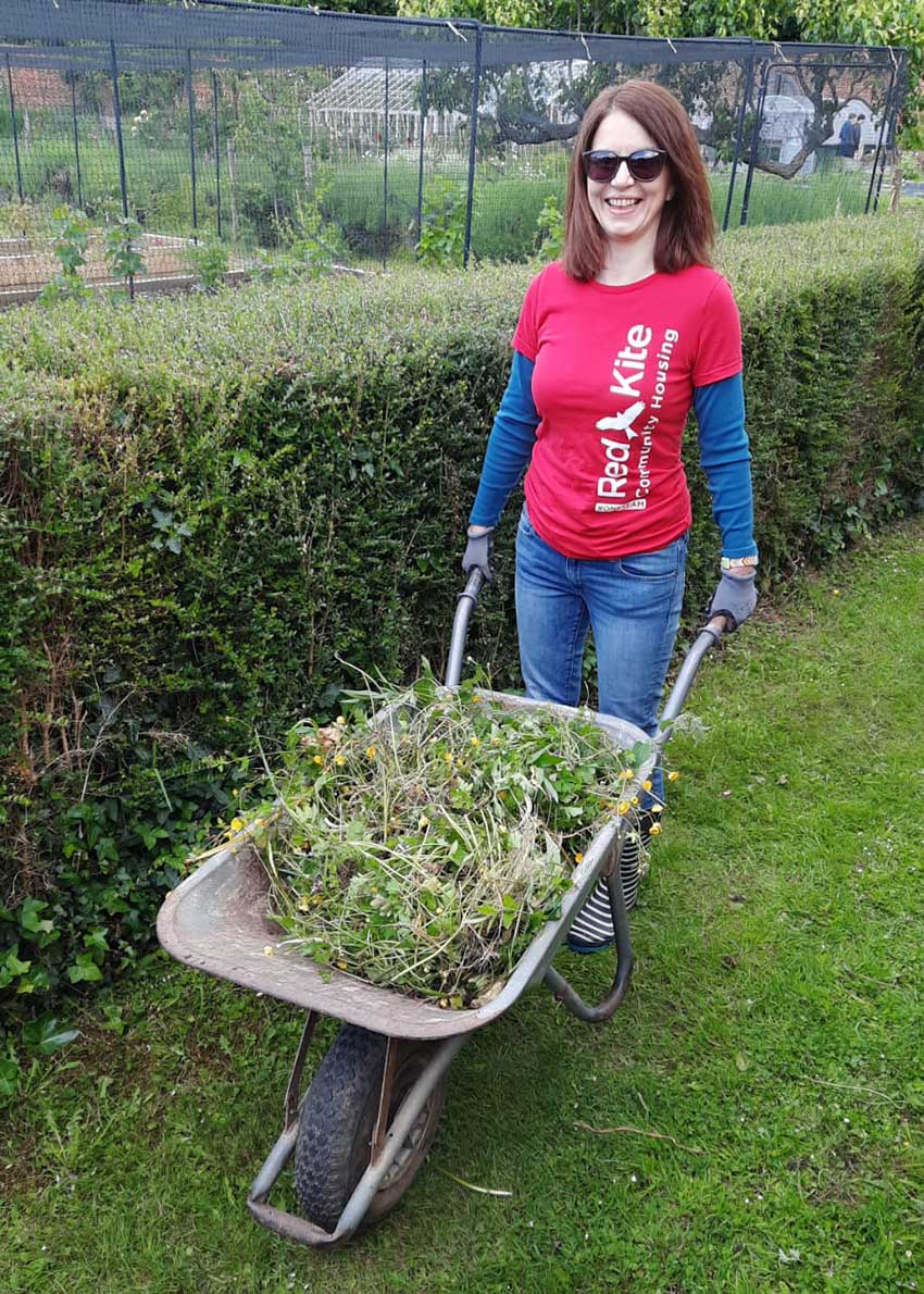 A Red Kite staff member pushing a wheelbarrow at the Lady Ryder Memorial Garden